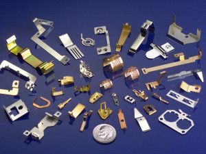 various metal stamping products around a coin